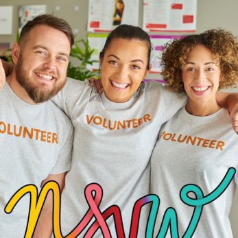 Three people wearing t-shirts with volunteer written on them