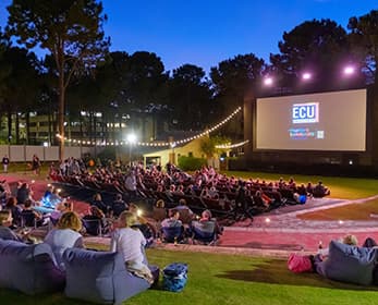 Outdoor cinema at Joondalup people sitting in deckchairs and bean bags facing the screen