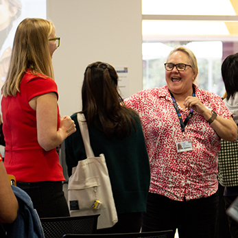 Students and staff laughing while participating on a workshop.